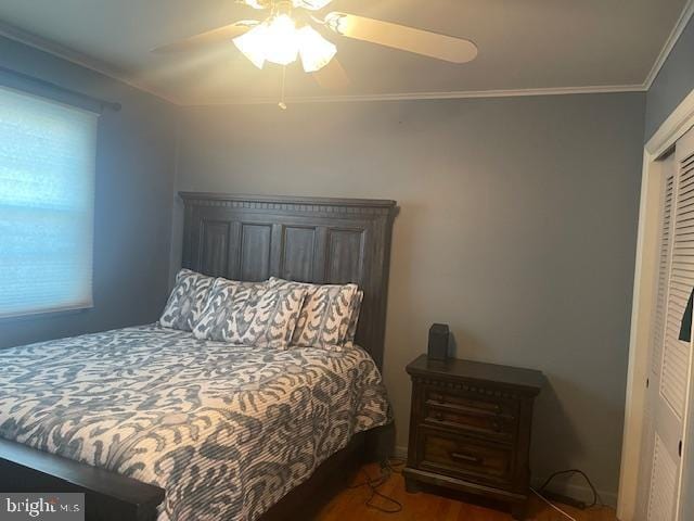 bedroom with ceiling fan, a closet, wood finished floors, and ornamental molding