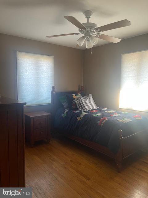 bedroom with ceiling fan and wood finished floors