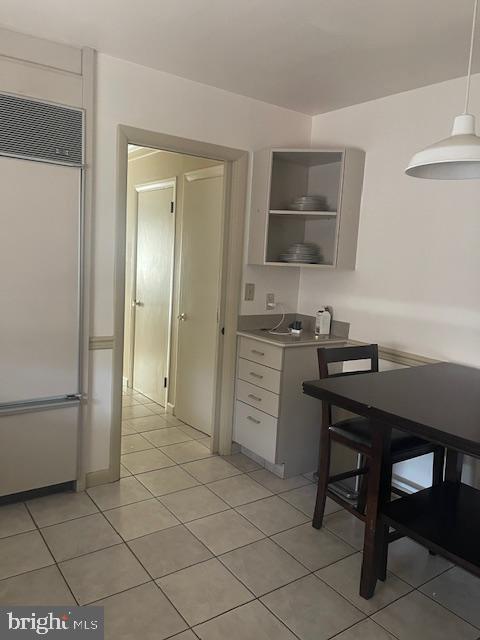 kitchen featuring built in refrigerator, light countertops, light tile patterned flooring, white cabinets, and open shelves