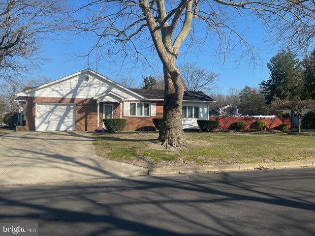 view of front of home featuring a front yard, an attached garage, and driveway