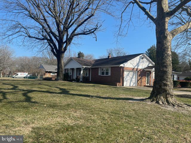 view of property exterior featuring a garage, a lawn, and a chimney