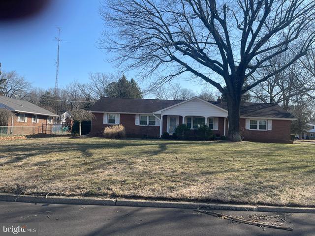 ranch-style home with a front lawn and fence