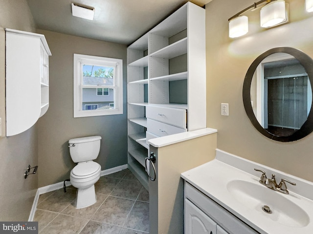 bathroom featuring tile patterned flooring, toilet, vanity, and baseboards