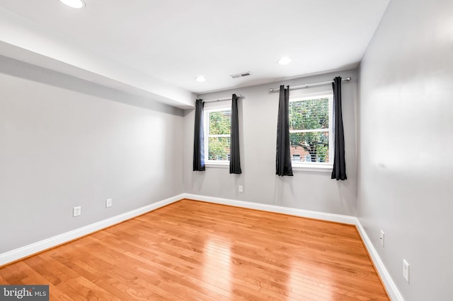 empty room with recessed lighting, visible vents, baseboards, and wood-type flooring