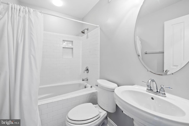 bathroom featuring a sink, toilet, and shower / bath combo