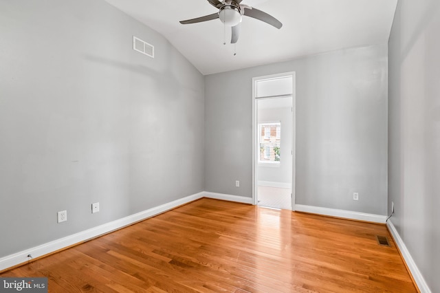 unfurnished room with ceiling fan, visible vents, baseboards, and wood finished floors