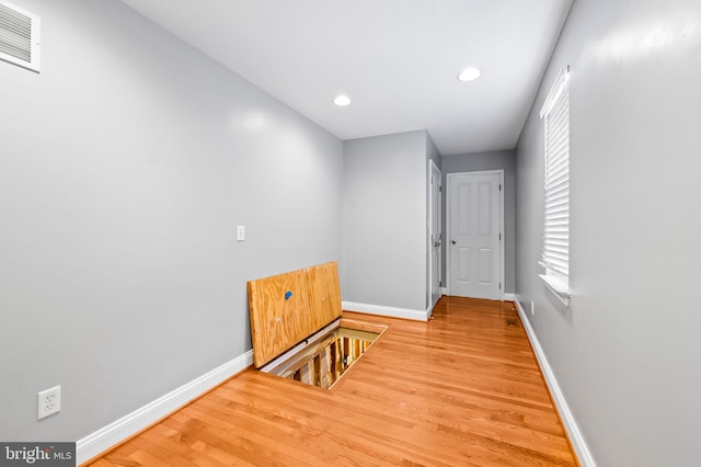 hall featuring wood finished floors, recessed lighting, baseboards, and visible vents