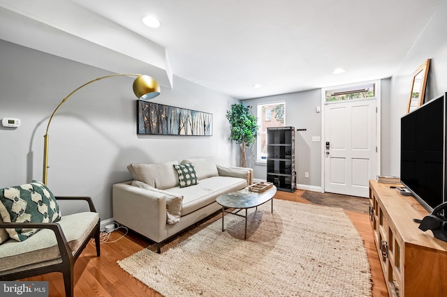 living room featuring recessed lighting, light wood-type flooring, and baseboards