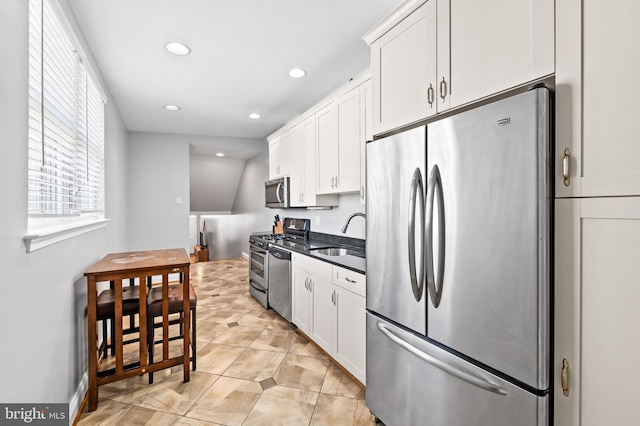 kitchen with recessed lighting, a sink, stainless steel appliances, white cabinets, and dark countertops