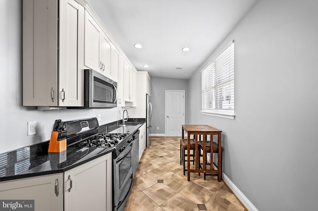 kitchen featuring a sink, white cabinetry, recessed lighting, stainless steel appliances, and baseboards