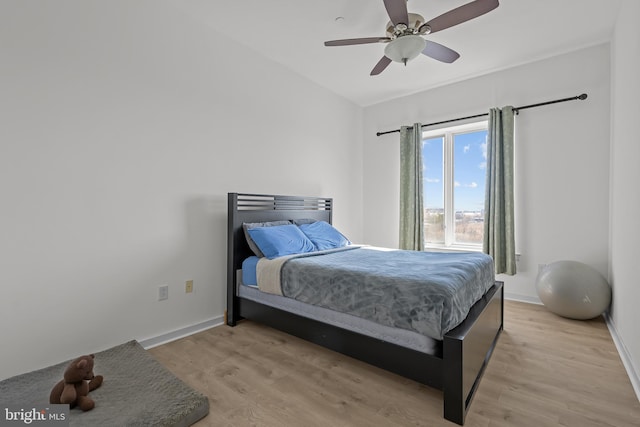 bedroom featuring light wood-type flooring, baseboards, and a ceiling fan