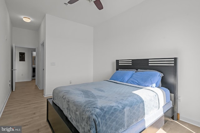 bedroom featuring light wood finished floors, ceiling fan, and baseboards