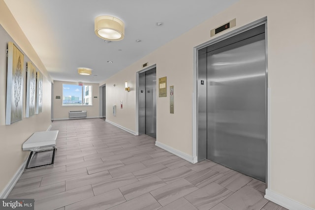 corridor with elevator and baseboards