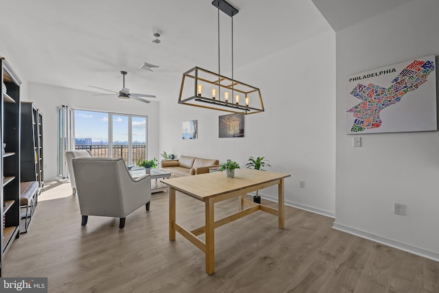 living room with visible vents, a ceiling fan, baseboards, and light wood finished floors