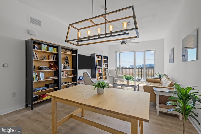 dining area with visible vents, light wood-style flooring, baseboards, and ceiling fan