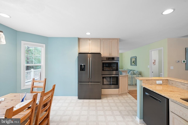 kitchen featuring recessed lighting, light stone countertops, light floors, and appliances with stainless steel finishes