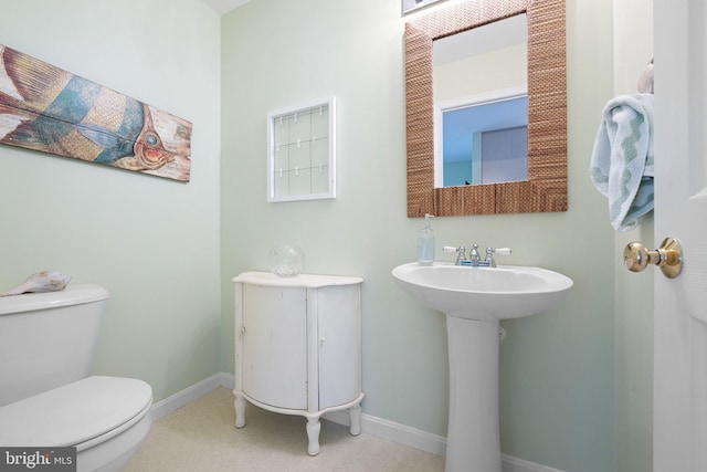 bathroom featuring toilet and baseboards