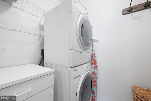 laundry area with stacked washer and dryer and laundry area