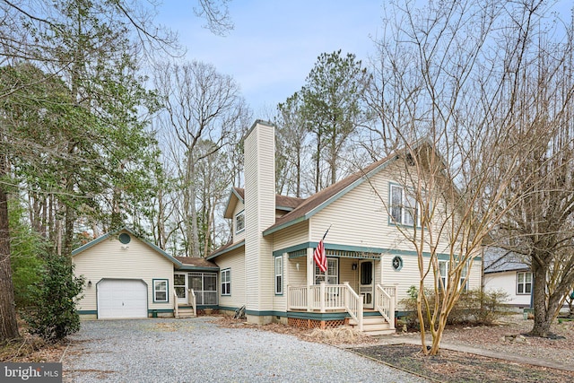 view of front of property with an attached garage, covered porch, driveway, and a chimney