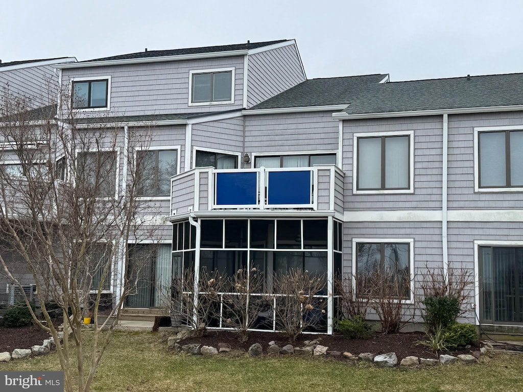 back of house featuring a balcony and a sunroom