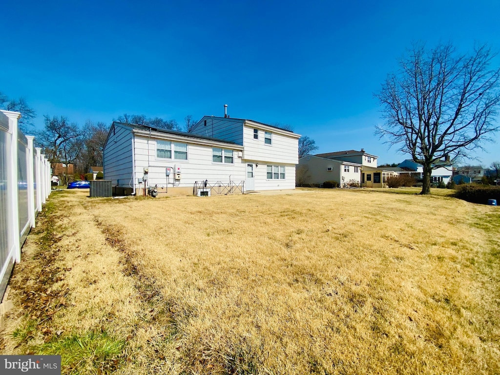 rear view of property featuring a lawn