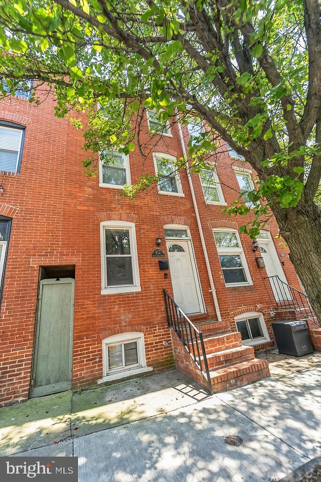 townhome / multi-family property with entry steps and brick siding