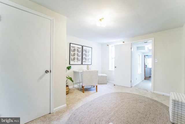 interior space featuring light colored carpet and baseboards