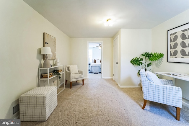 living area with baseboards, carpet floors, and ceiling fan