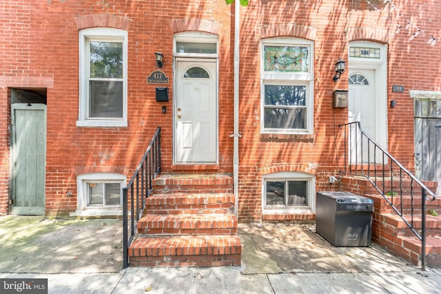 doorway to property featuring brick siding