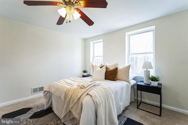 carpeted bedroom featuring baseboards, visible vents, and ceiling fan