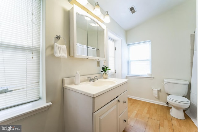 bathroom with visible vents, baseboards, toilet, wood finished floors, and vanity