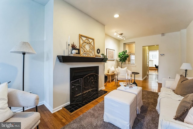 living room with recessed lighting, a fireplace, baseboards, and wood finished floors