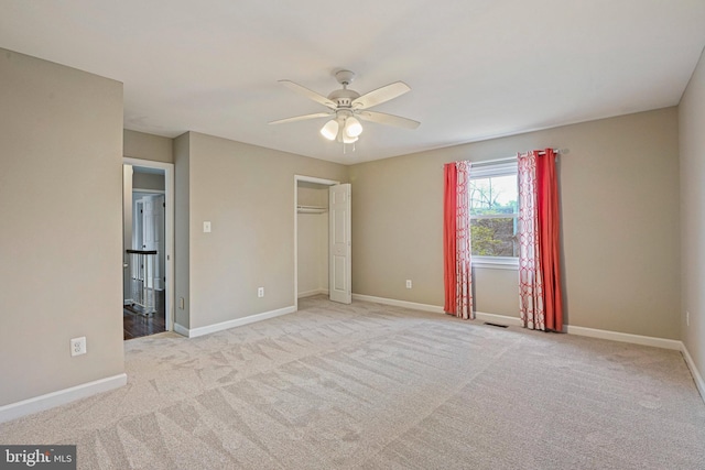 unfurnished bedroom featuring a ceiling fan, visible vents, carpet, and baseboards