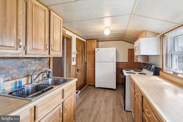 kitchen with light countertops, white appliances, light wood-style floors, vaulted ceiling, and backsplash