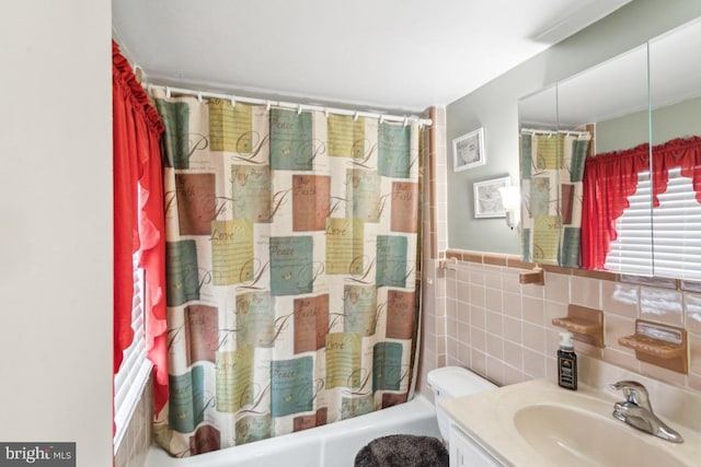 full bathroom with shower / tub combo with curtain, vanity, tile walls, and toilet