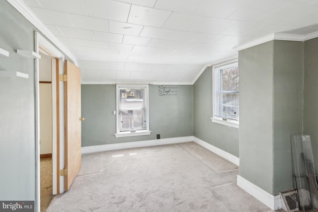 basement featuring ornamental molding, baseboards, carpet, and a healthy amount of sunlight