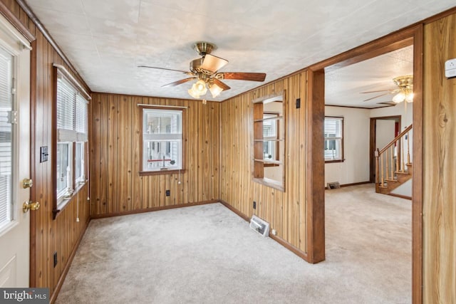 empty room featuring ceiling fan, carpet, and a wealth of natural light