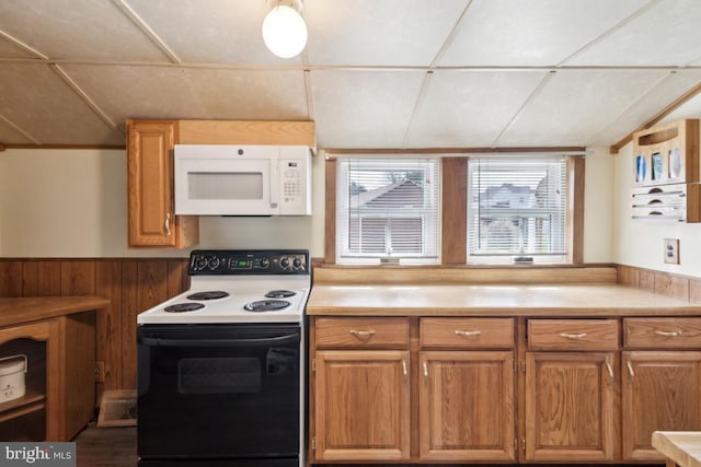 kitchen featuring white microwave, range with electric stovetop, light countertops, and brown cabinetry