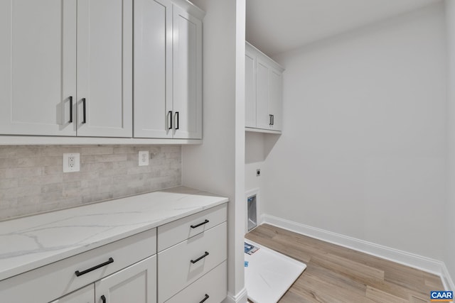 laundry room featuring light wood-style floors, cabinet space, baseboards, and hookup for an electric dryer