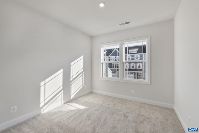 carpeted empty room with visible vents and baseboards