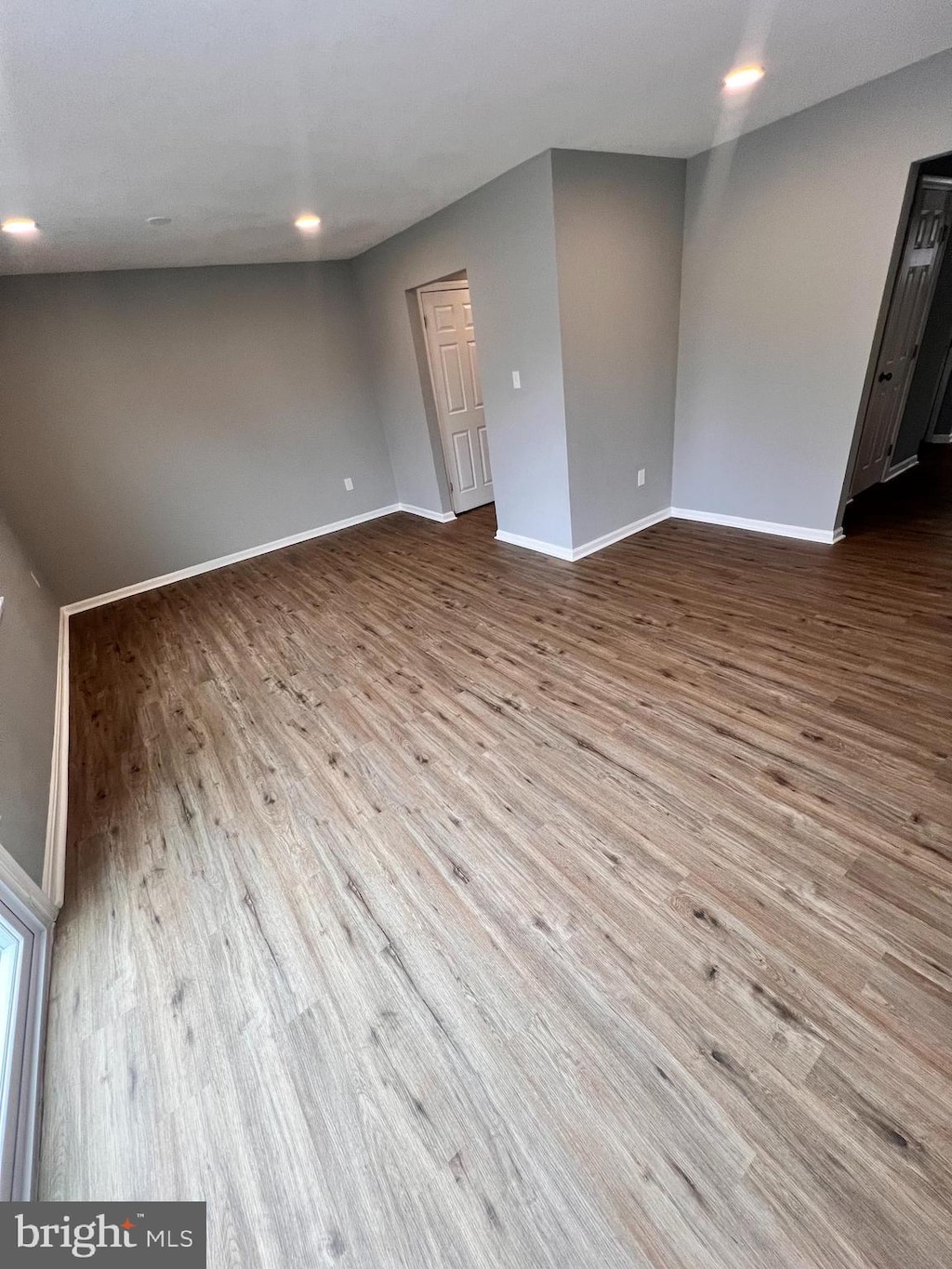 spare room featuring recessed lighting, baseboards, and wood finished floors