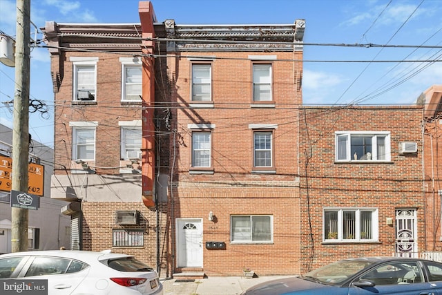 view of front facade with cooling unit and brick siding