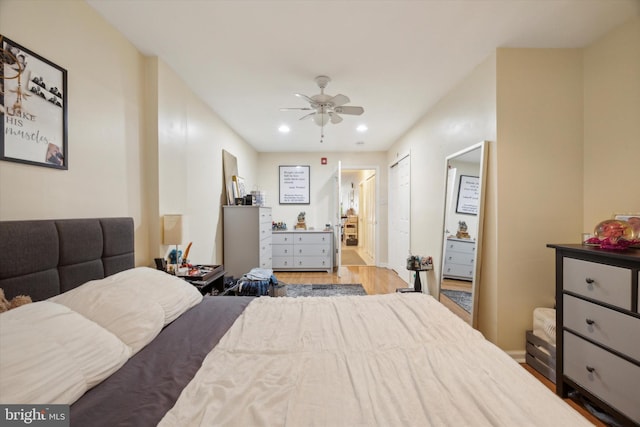 bedroom featuring a ceiling fan, wood finished floors, baseboards, ensuite bath, and recessed lighting