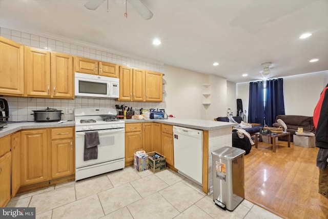 kitchen with white appliances, a peninsula, light countertops, open floor plan, and backsplash