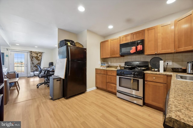 kitchen featuring recessed lighting, decorative backsplash, black appliances, and light wood finished floors