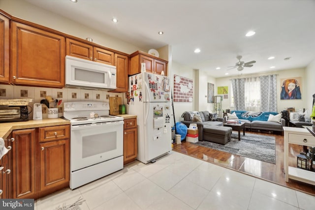 kitchen with white appliances, brown cabinetry, light countertops, and ceiling fan