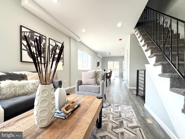 living area with stairs, recessed lighting, wood finished floors, and baseboards