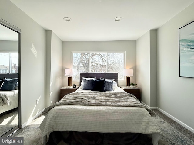 bedroom with carpet flooring, multiple windows, and baseboards