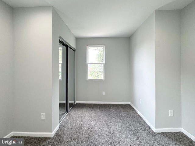 unfurnished bedroom featuring a closet, baseboards, and carpet floors