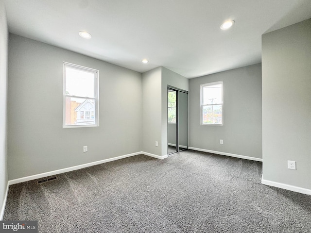 unfurnished bedroom with recessed lighting, visible vents, dark carpet, and baseboards